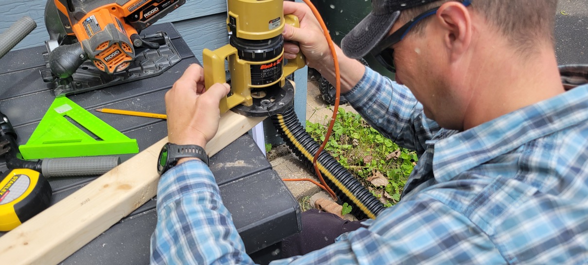 man operating a woodworking router on a two by four