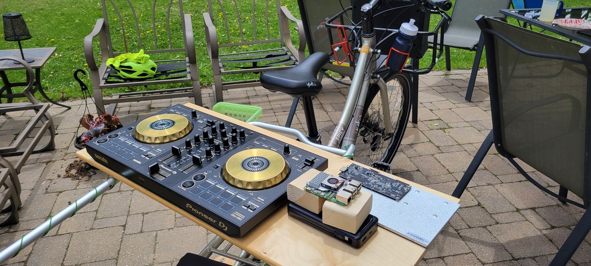 dj controller, raspberry pi, touchscreen display on a wood tray on the back of a cargo bicycle